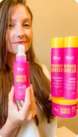 Mulher com o spray e o kit Engrossa Cabelo
